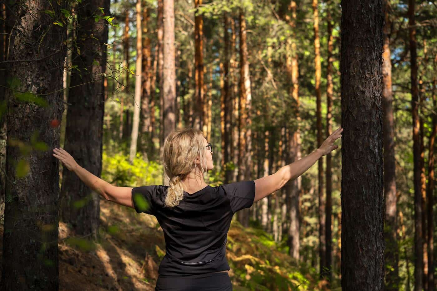 Beautiful woman walking through the forest, idea of restoring health and relaxation, forest baths