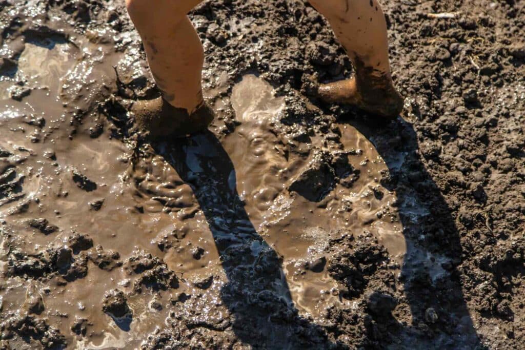 Child playing in mud. Selective focus. Kid.